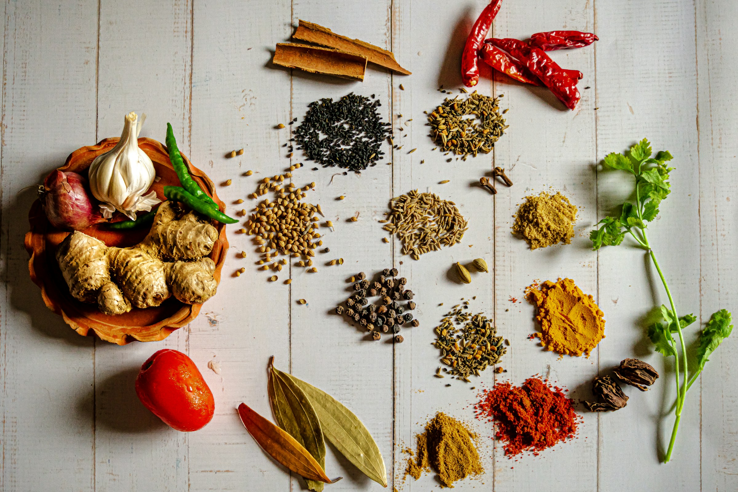 Whole spices arranged in a wooden bowl